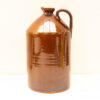 Classic brown ceramic jug with glossy glaze, sturdy handle, and timeless charm.