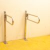 Modern stainless steel handrails on a light wall with bold yellow floor for enhanced safety.