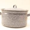 Vintage gray enamel pot with well-worn handles and snug lid, perfect for home-cooked meals.