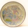 Vintage plate showcasing coastal life with a woman balancing a basket in vibrant relief design.