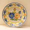 Vibrant handgemaakt keramisch bord met bloemdessin, perfect voor decoratie of als verzamelobject.