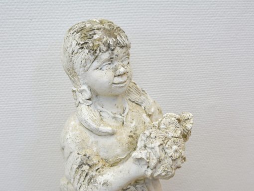 Charming vintage girl statue holding flowers, perfect for nostalgic home and garden decor.