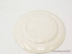 Elegant white ceramic plate with textured circular patterns, ideal for stylish dining and presentations.