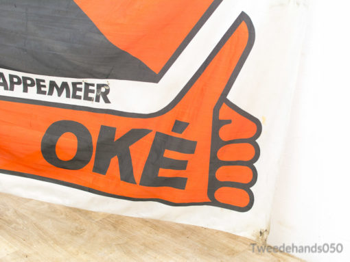 Vibrant OKÉ banner promoting community positivity at Appemeer events with a cheerful thumbs-up gesture.