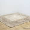 Elegant beige shag rug adds comfort and warmth to your homes cozy corner.