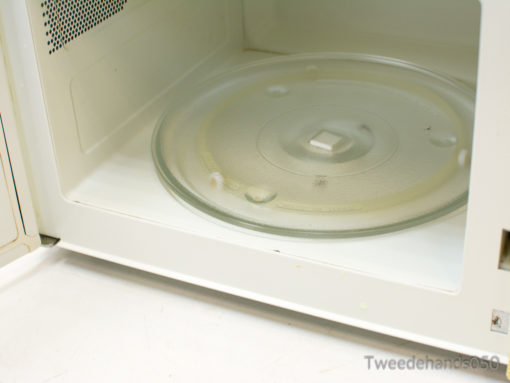 Vintage microwave with glass turntable, perfect for quick meals and charming retro style.