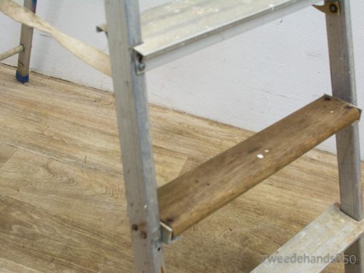 Sturdy vintage aluminum ladder with wooden steps, perfect for home improvement and DIY projects.