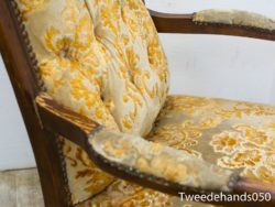 Elegant vintage armchair with gold and cream floral upholstery, perfect for timeless home decor.