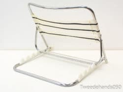 Sleek chrome chair with striped fabric, perfect for modern indoor and outdoor aesthetics.