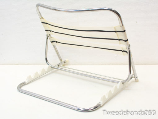 Sleek chrome chair with striped fabric, perfect for modern indoor and outdoor aesthetics.
