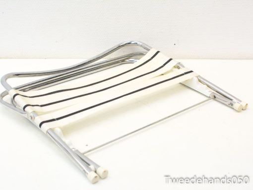 Sleek chrome folding chair with striped fabric, perfect for modern indoor and outdoor spaces.