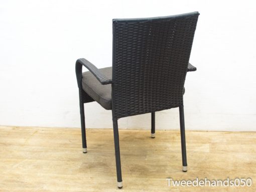 Contemporary wicker chair with plush gray cushion for versatile outdoor and indoor comfort.