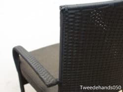 Stylish wicker chair with elegant black weave and luxurious beige cushion for any decor.