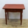 Charming vintage red table with drawer and elegant legs, perfect for cozy home decor.