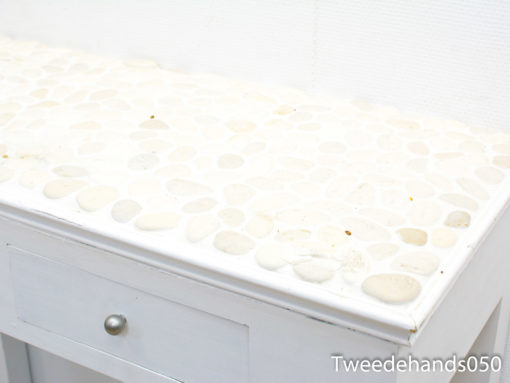 Elegant table with pebble top and drawer, ideal for modern coastal decor.