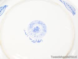 Antique porcelain plate featuring blue floral designs and cultural inscriptions, perfect for collectors.
