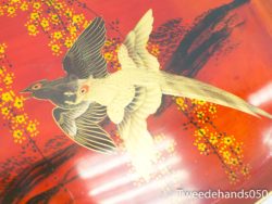 Elegant birds in harmony surrounded by yellow flowers against a vibrant red background.