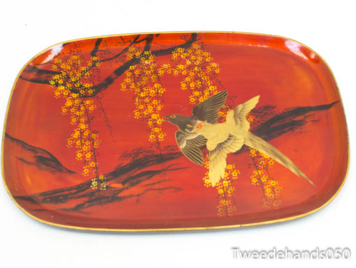 Elegant red tray featuring a graceful bird and vibrant floral decorations for stylish serving.