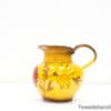 Charming yellow ceramic jug adorned with floral designs, perfect for decoration or serving.