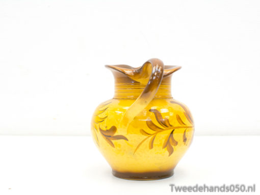 Elegant yellow ceramic jug with intricate leaf designs, perfect for decor or daily use.