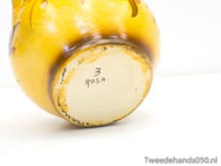 Charming yellow ceramic vase with artistic motifs, perfect for decor and floral displays.