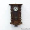 Elegant vintage wooden wall clock with ornate details and Roman numerals, perfect for classic decor.