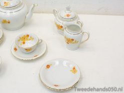 Elegant vintage tea set with vibrant floral designs and gold trim for stylish gatherings.