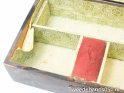 Antique wooden box with green floral lining and red velvet, ideal for storing treasures.