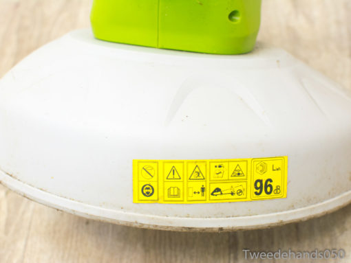 Ergonomic green and white garden trimmer with safety labels for effective outdoor maintenance.