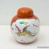 Colorful dragon porcelain jar with orange lid, perfect for decor or unique gifts.
