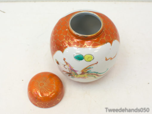 Vibrant ceramic jar with dragon motifs and orange lid, adding artistic flair to your decor.