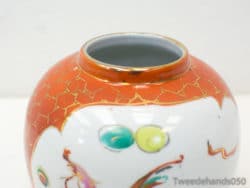 Elegant orange vase with gold accents and abstract designs, perfect for stylish home decor.