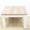 Stylish light wood table with white legs, perfect for modern and cozy spaces.