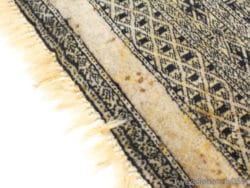 Vintage geometric rug with unique patterns and fringe, adding character to any interior space.