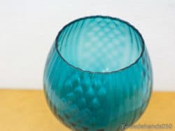 Artistic turquoise glass vase with textured patterns and wavy rim, ideal for stylish decor.
