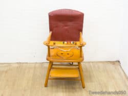 Vintage wooden childrens chair with a red backrest and colorful bead accents for fun activities.