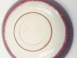 Elegant off-white ceramic bowl with glossy maroon rim, perfect for dining and decor.