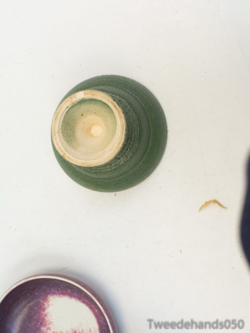 Stylish green ceramic bowl with cream interior and unique purple marbled dish for vintage flair.