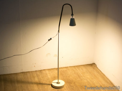 Elegant floor lamp with dark blue shade, providing warm light for stylish modern interiors.