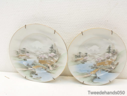 Elegant porcelain plates displaying serene landscapes and cherry blossoms for refined home decor.