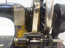 Vintage black sewing machine with gold accents, showcasing intricate craftsmanship and timeless elegance.