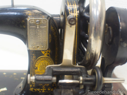 Vintage black sewing machine with gold accents, showcasing intricate craftsmanship and timeless elegance.