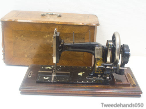 Antique black sewing machine with elegant wooden case, showcasing vintage craftsmanship and historical design.