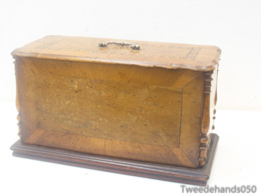 Antique wooden box with elegant carvings and a decorative handle, perfect for storage and decor.