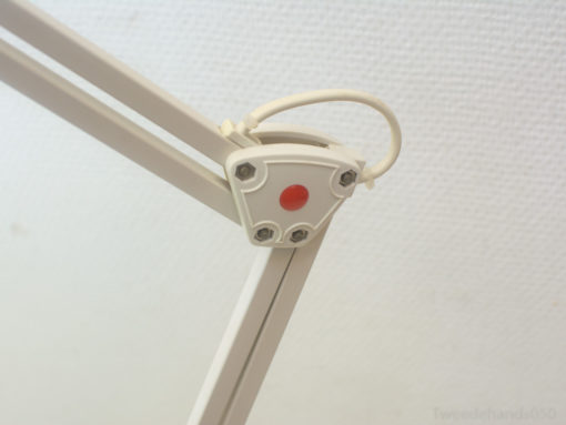Stylish desk lamp with flexible arm and bright red button, enhancing modern workspace functionality.