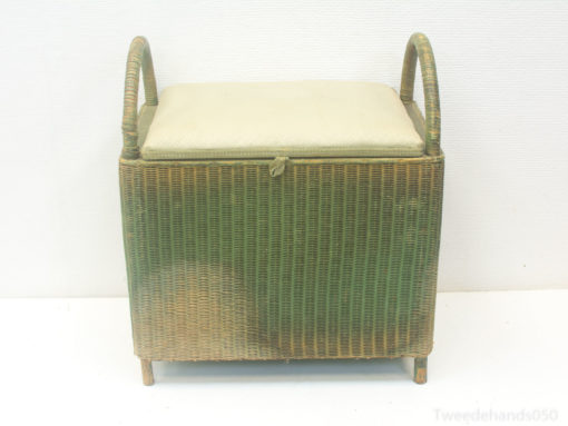 Stylish rattan storage box with cushion and handles for extra seating and organization.