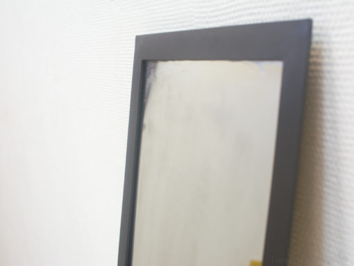 Sleek black mirror with minimalist design enhances elegance in contemporary spaces.