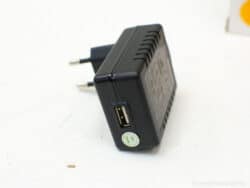 Compact black USB wall charger with quick charge capability for smartphones and tablets.