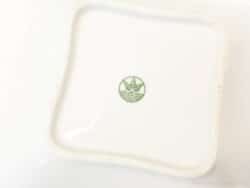 Elegant white porcelain dish with green lotus motif, perfect for serving and decor.