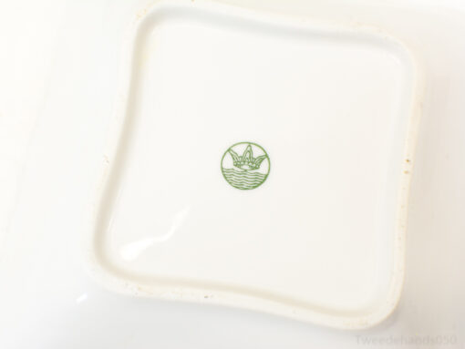 Elegant white porcelain dish with green lotus motif, perfect for serving and decor.